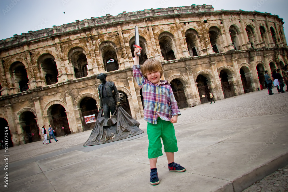 Enfant jouant devant les arènes de Nîmes