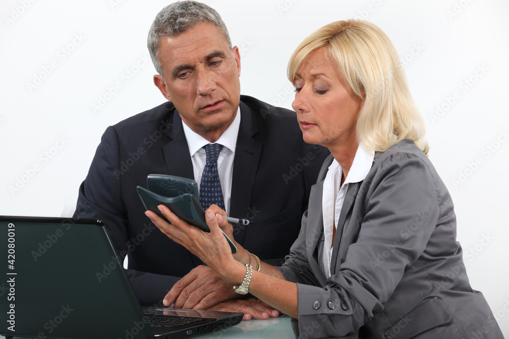 businessman and businesswoman calculating the budget businessman and businesswoman calculating the budget