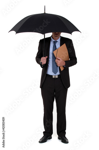A businessman with an umbrella. © auremar