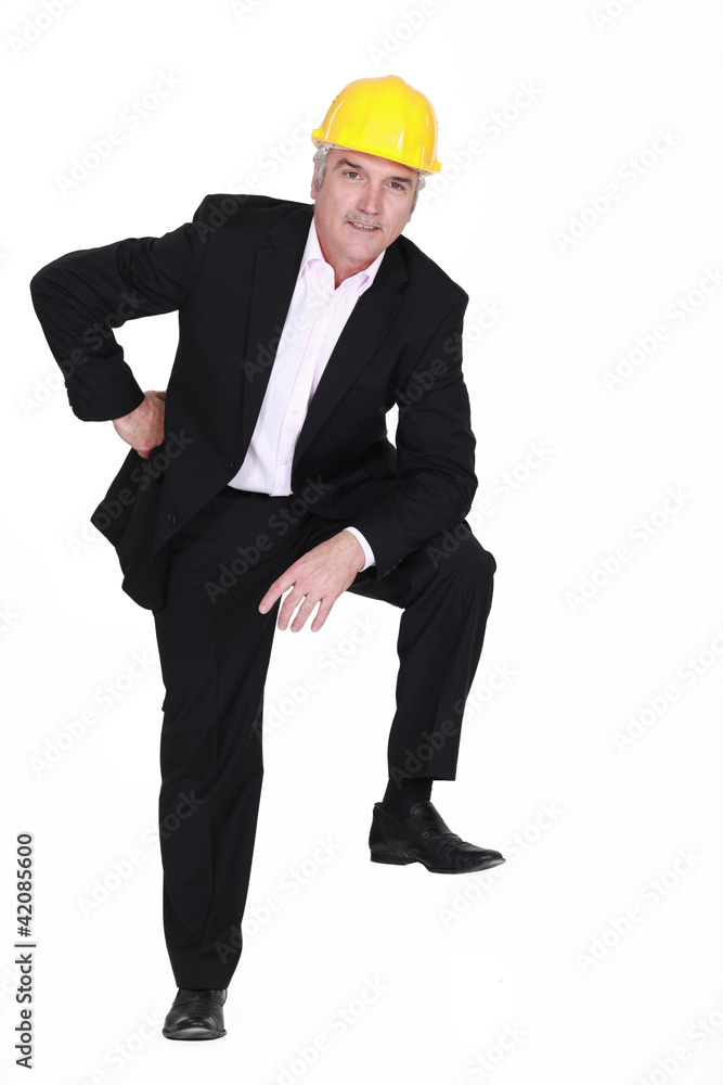 Man with helmet and foot resting on invisible object Man with helmet and foot resting on invisible object