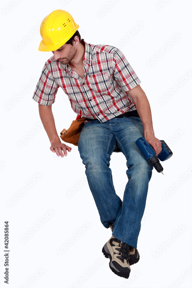 Construction worker sitting on blank space looking down Construction worker sitting on blank space looking down