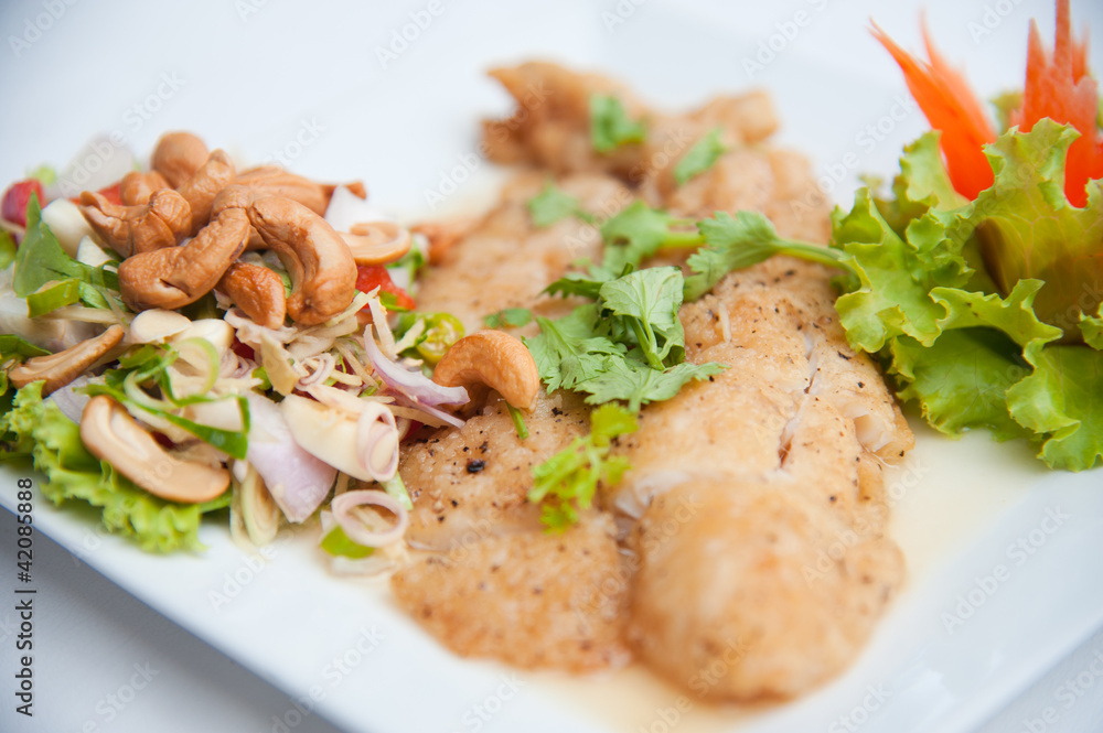 Deep fried fish serve with spicy salad and vegetables Deep fried fish serve with spicy salad and vegetables
