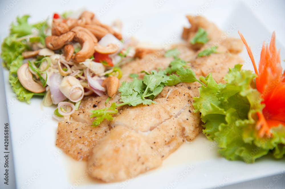 Deep fried fish serve with spicy salad and vegetables