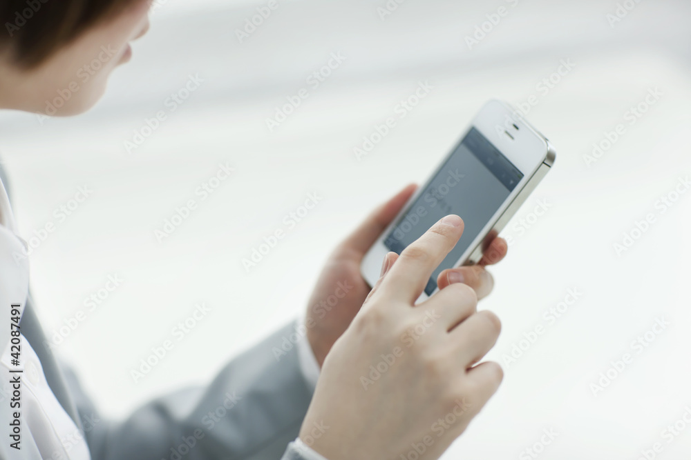 スマートフォンを操作するビジネスウーマン