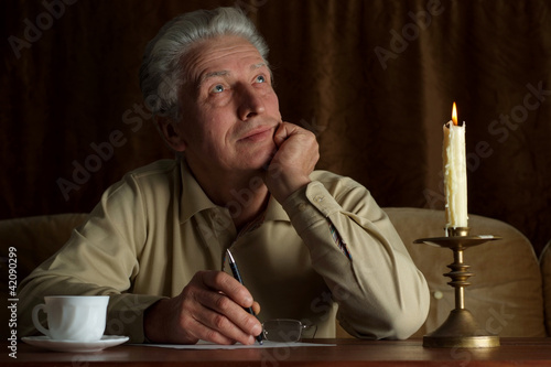 Handsome caucasian man sits at a table photo