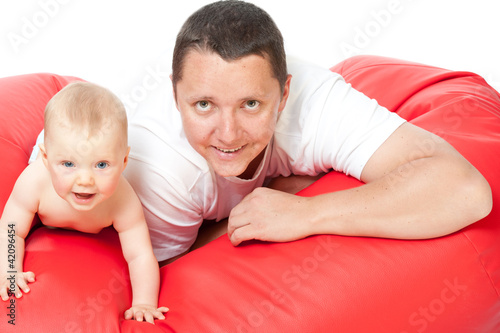 father with baby on red sofa