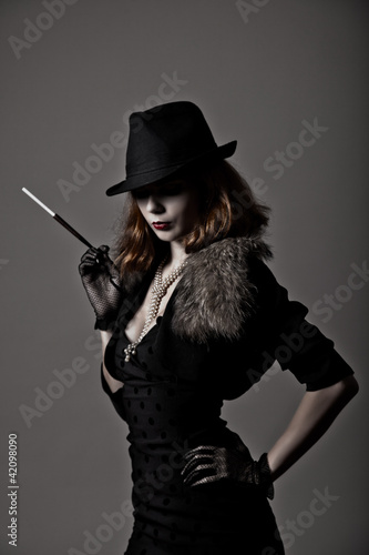 Retro shot of gangster woman in fedora hat