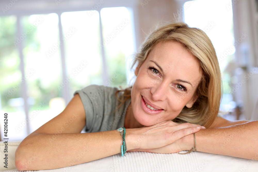 Beautiful blond mature woman relaxing in sofa Beautiful blond mature woman relaxing in sofa