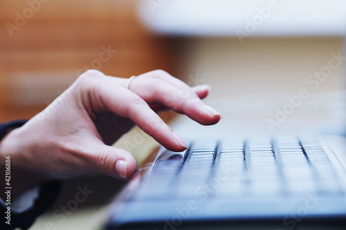 human hand going to press key on keyboard