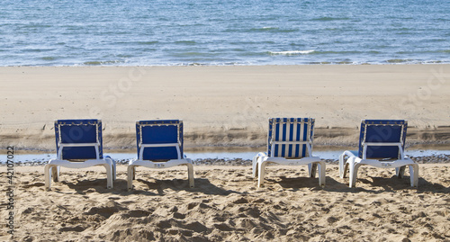 sunloungers lined up on the beach © theclarkester