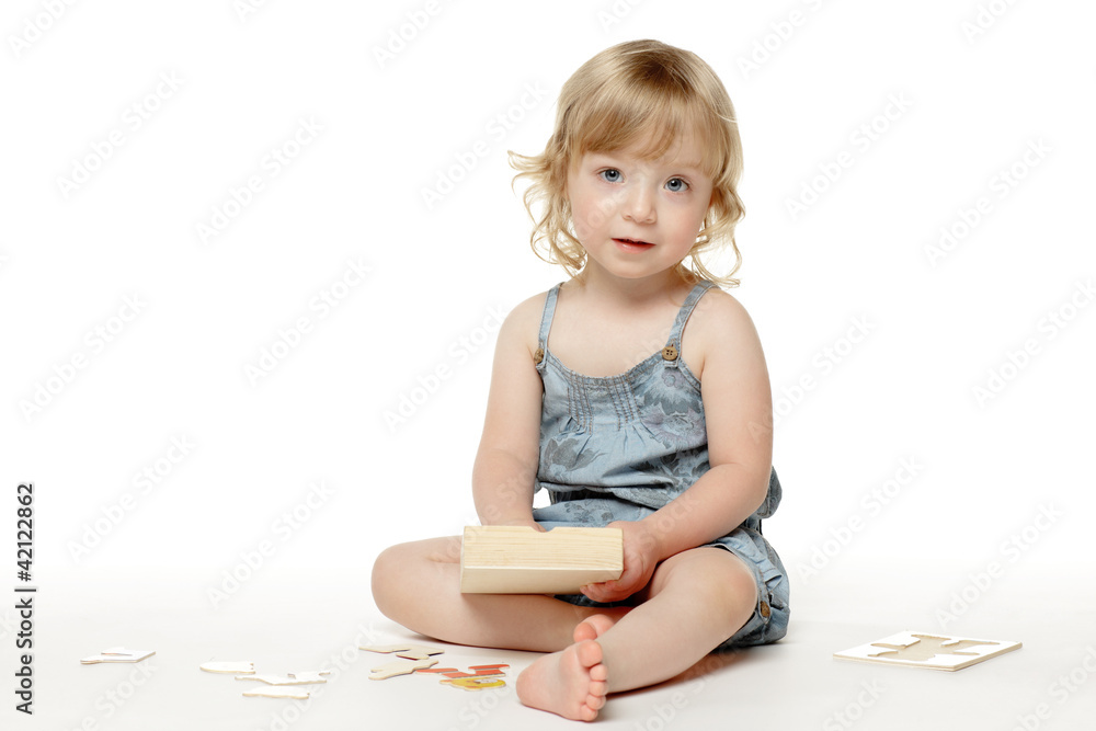2 years old child sitting with a toy on the floor 2 years old child sitting with a toy on the floor