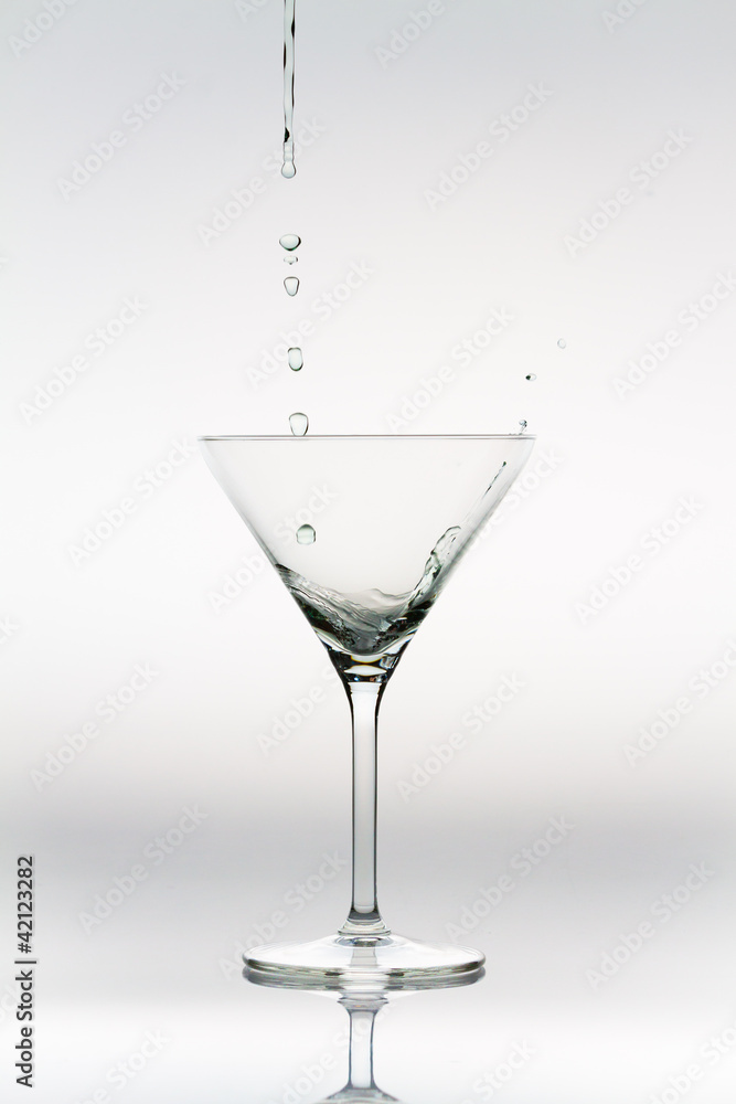 Drops of liquor falling into a cocktail glass