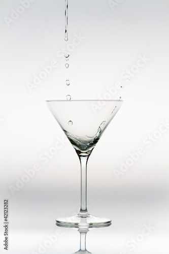 Drops of liquor falling into a cocktail glass