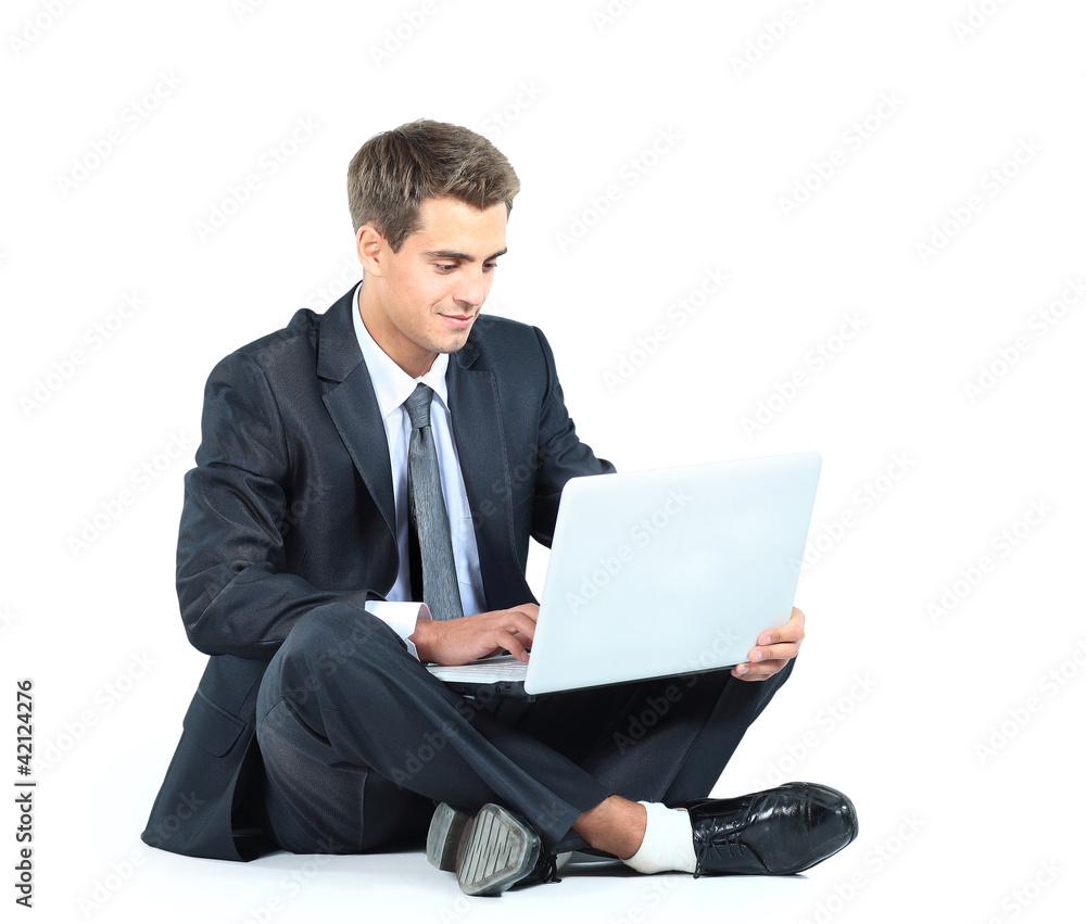 Isolated seated young businessman using a laptop Isolated seated young businessman using a laptop