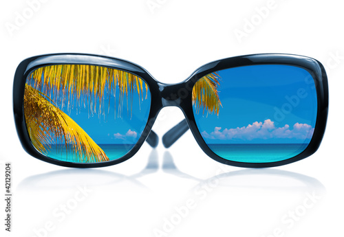 Sunglasses with a beach scene reflected on the glass