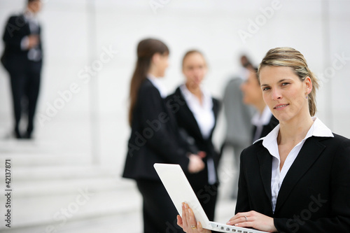Businesswoman with laptop outdoors