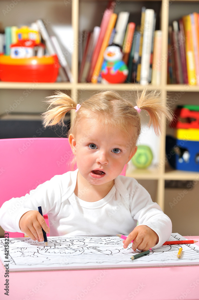 Fototapeta premium Kleines Mädchen malt mit Buntstiften
