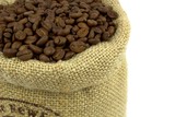 Roasted coffee beans and linen sack on white background