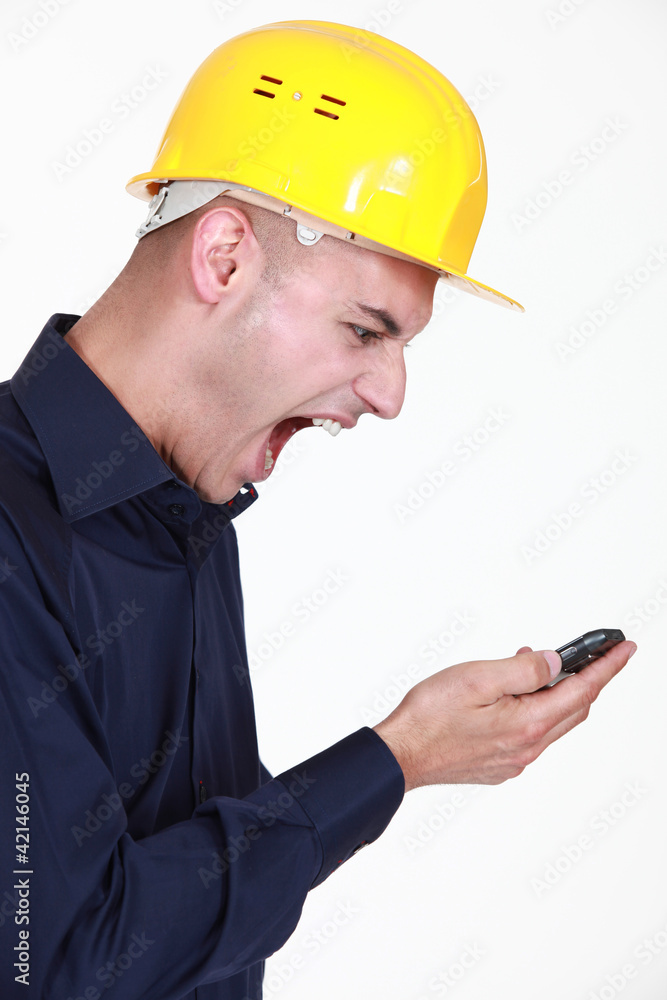 Tradesman screaming at his mobile phone Tradesman screaming at his mobile phone