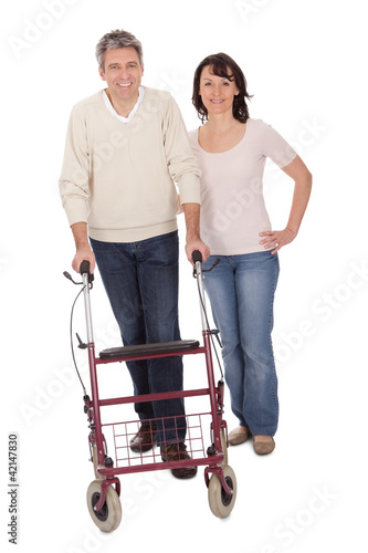 Mature couple using walking aide