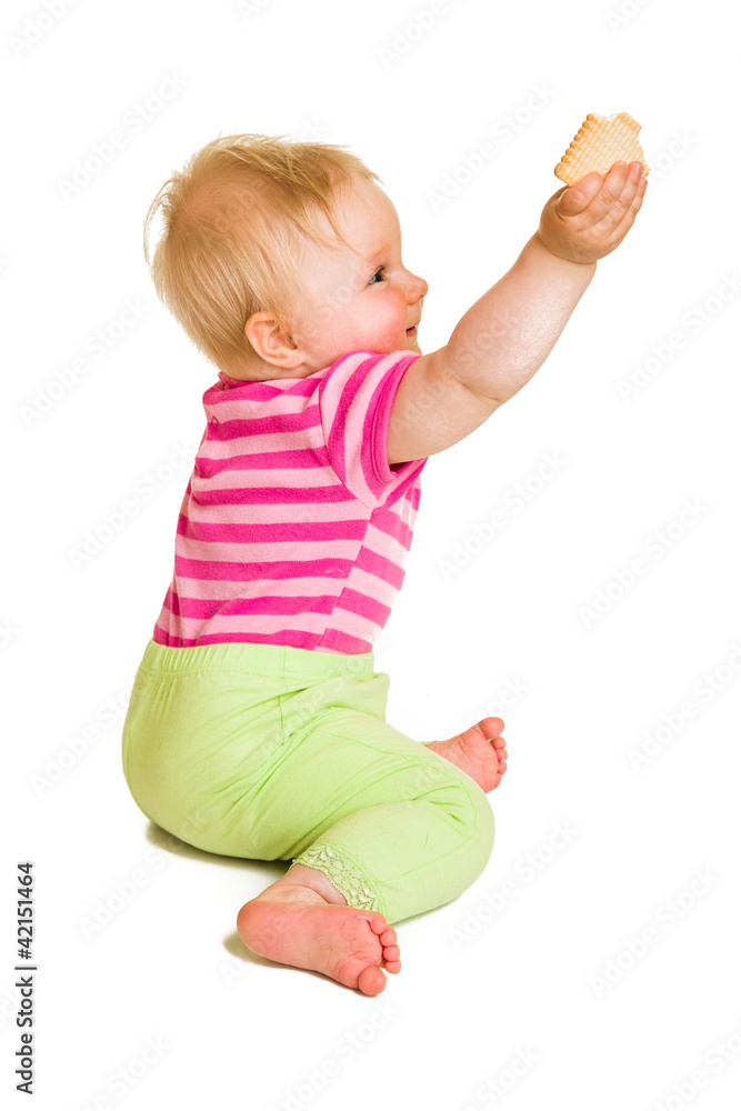 Infant baby learning to eat a biscuit