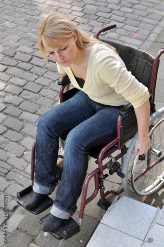 Rollstuhlfahrerin vor Hindernis