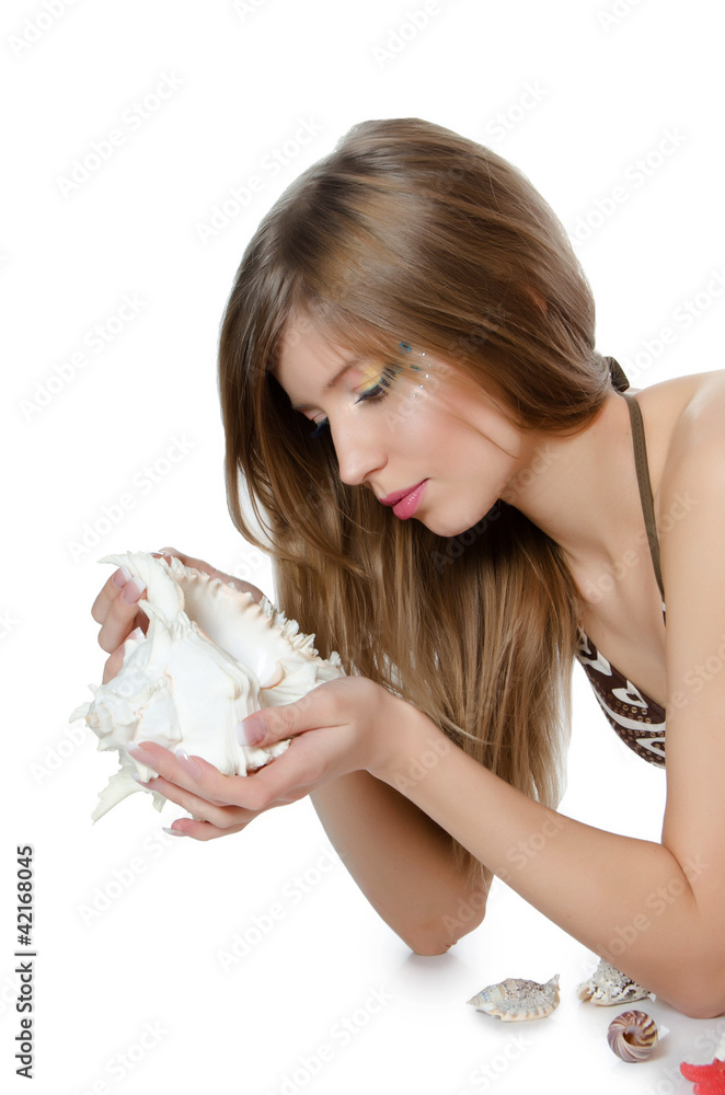 The young girl in bikini lays with seashells The young girl in bikini lays with seashells