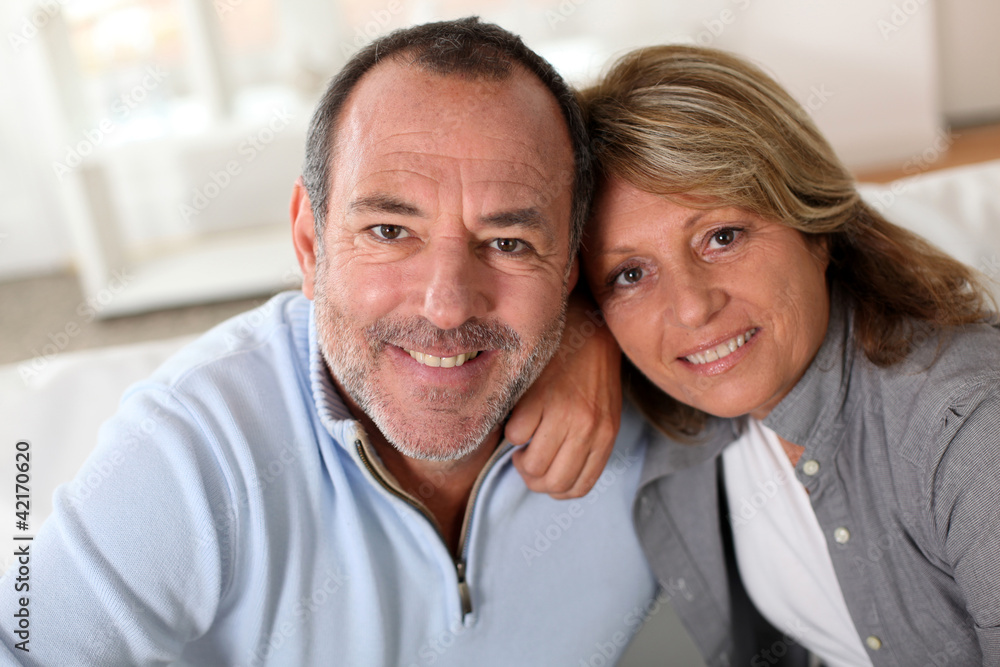 Portrait of happy senior couple sitting in sofa Portrait of happy senior couple sitting in sofa