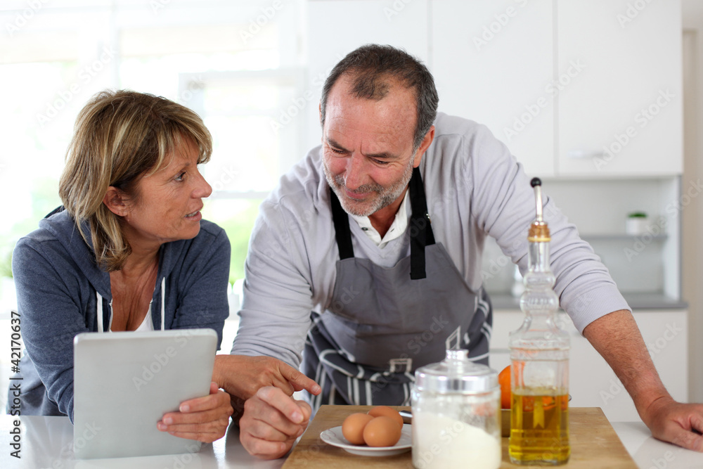 Senior couple having fun in home kitchen Senior couple having fun in home kitchen