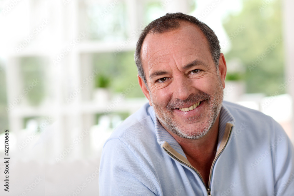 Portrait of senior man sitting in sofa at home Portrait of senior man sitting in sofa at home
