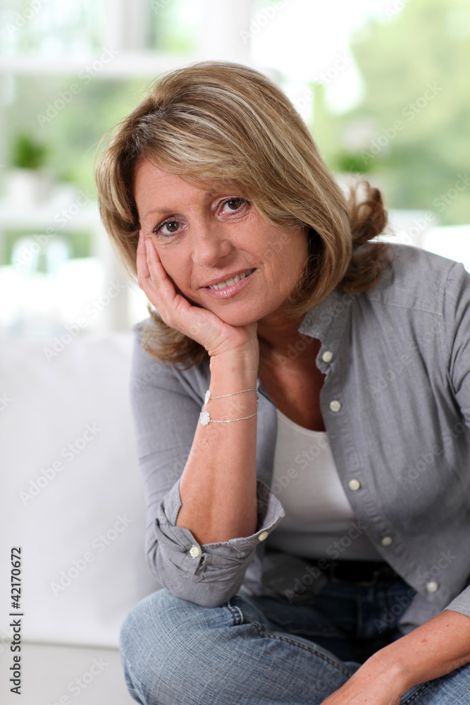 Senior woman at home sitting in sofa