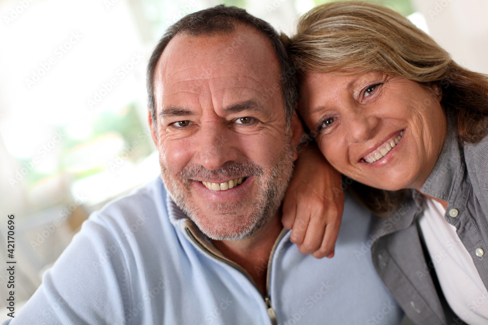 Portrait of happy senior couple sitting in sofa Portrait of happy senior couple sitting in sofa