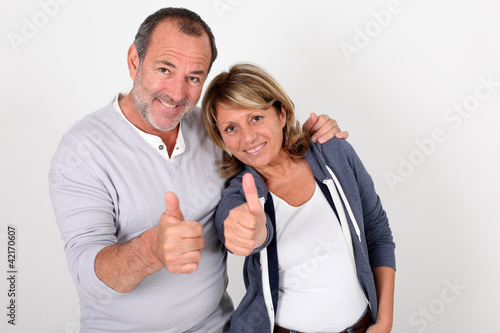 Portrait of senior couple showing thumbs up
