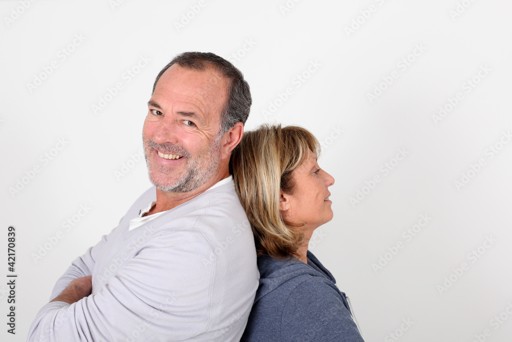 Senior couple standing back to back on white background Senior couple standing back to back on white background