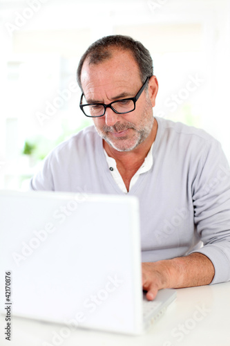 Senior businessman working on laptop from home