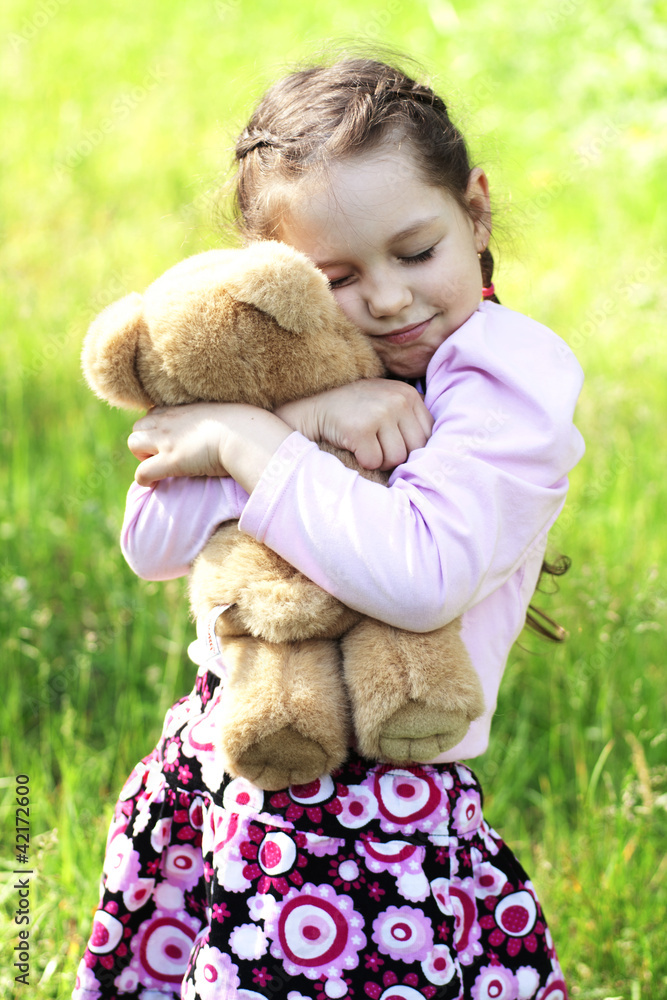 Little girl hugging teddy top bear
