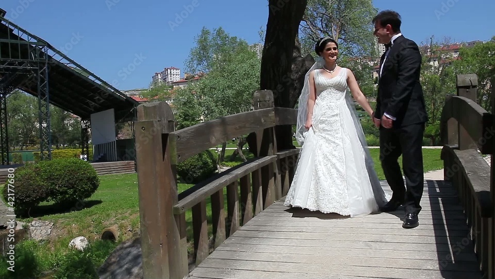 bride and groom walking on the bridge