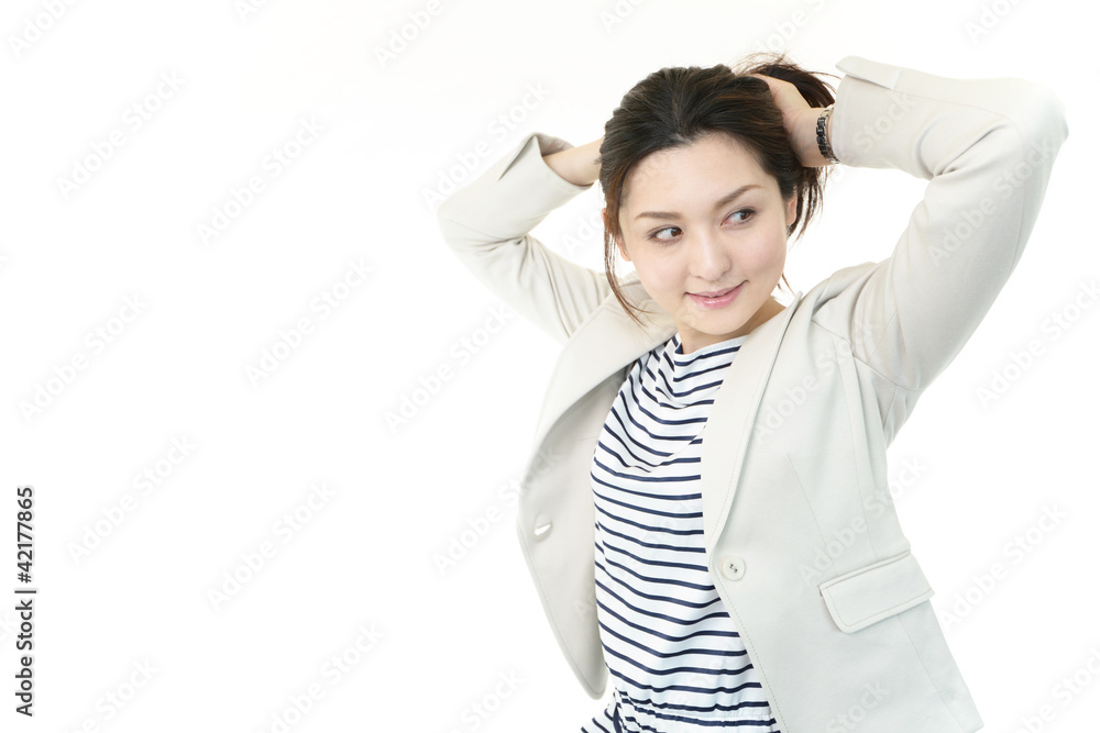 髪の毛をアップにする笑顔のオフィスレディー