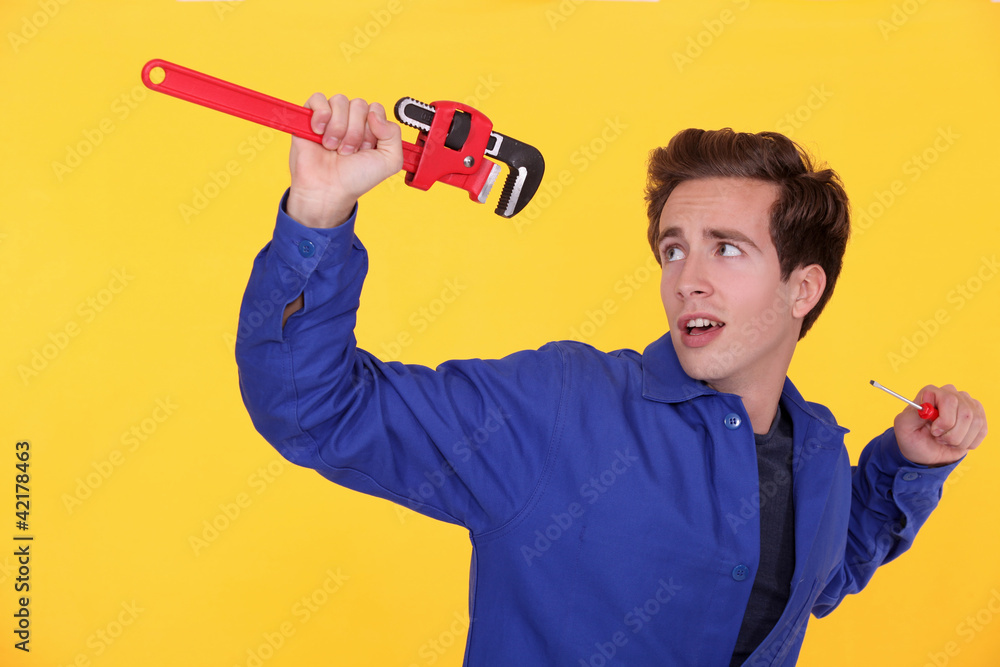 Man with a wrench and screwdriver Man with a wrench and screwdriver