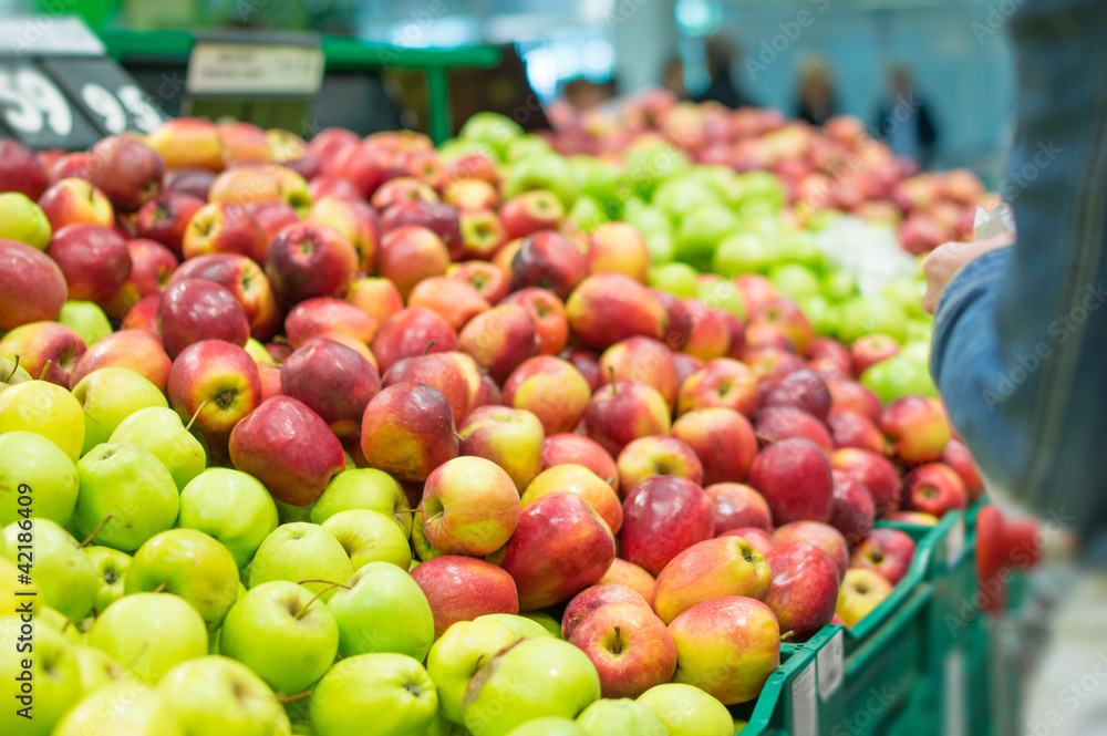 Variety of apples in boxes in supermarket