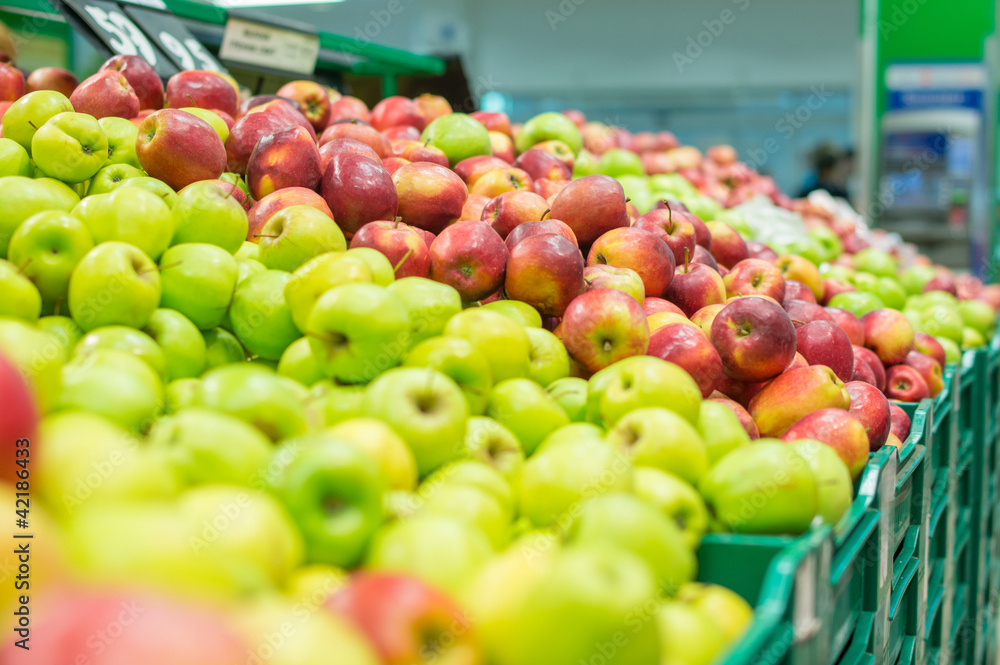 Variety of apples in boxes in supermarket