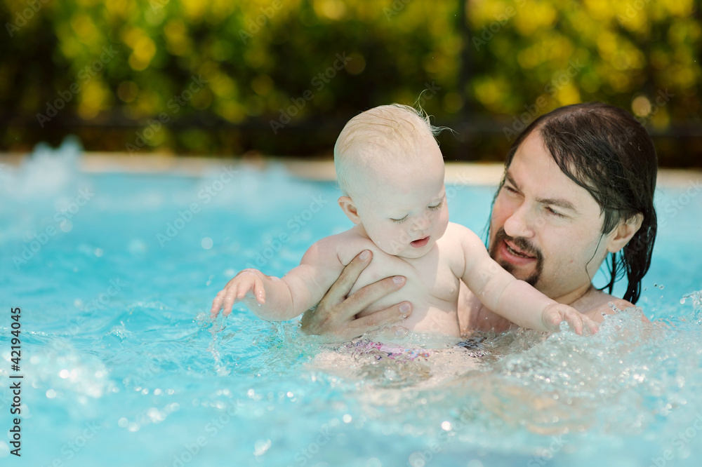 Father and daughter swimming in pool Father and daughter swimming in pool