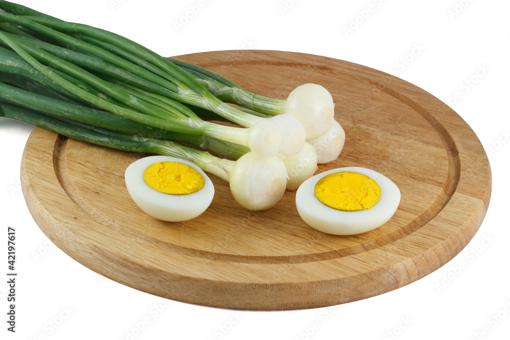 Green onions and half of the eggs on a wooden kitchen board Green onions and half of the eggs on a wooden kitchen board