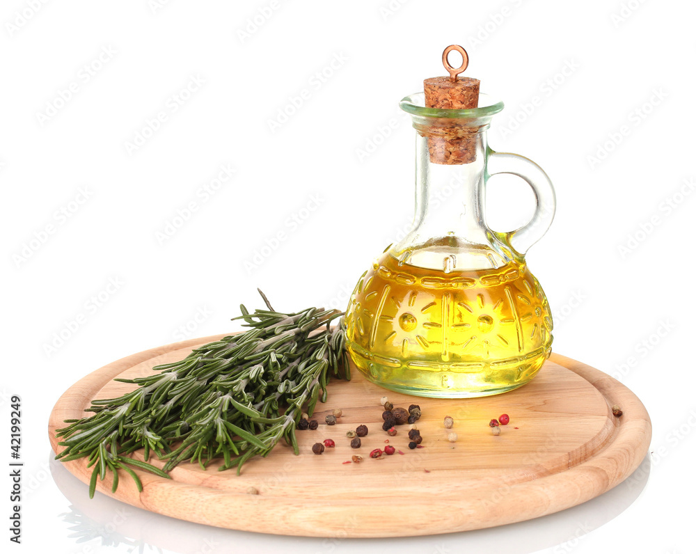 Oil in a bottle and fresh rosemaryon wooden board isolated Oil in a bottle and fresh rosemaryon wooden board isolated