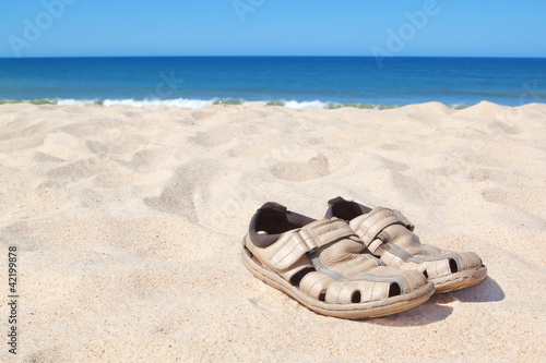 Sandals on the beach near the sea.