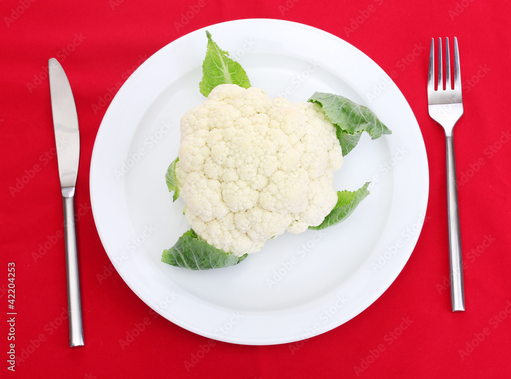 Fresh cauliflower on plate, knife and fork Fresh cauliflower on plate, knife and fork