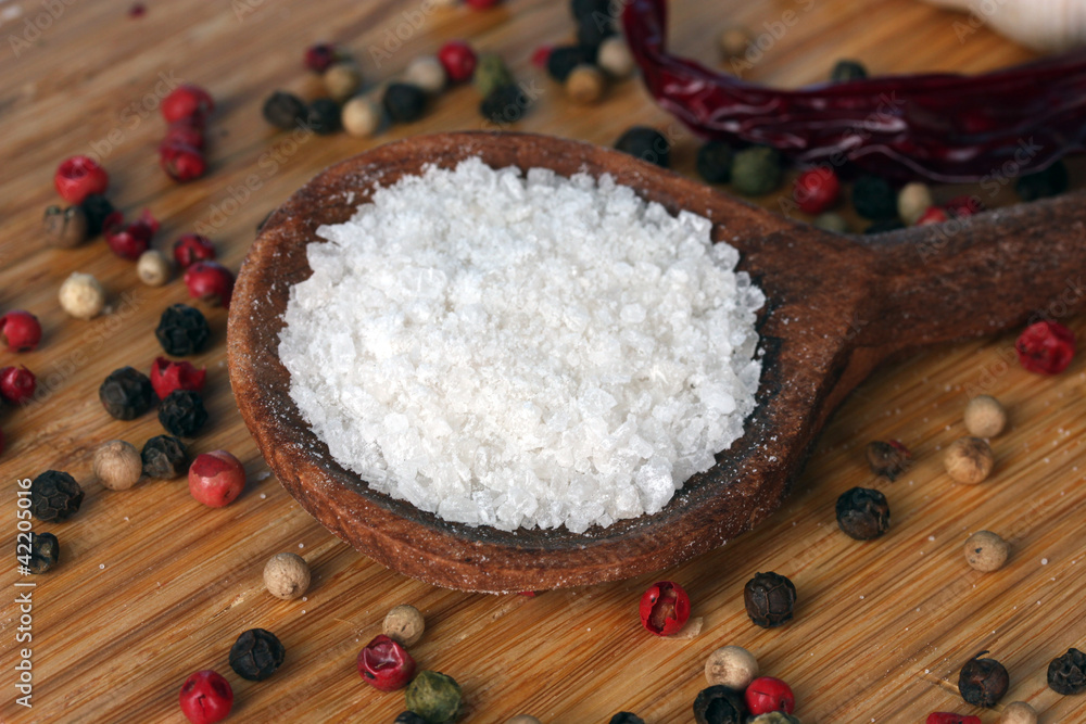 Sea salt in a wooden spoon on a cutting board close-up Sea salt in a wooden spoon on a cutting board close-up