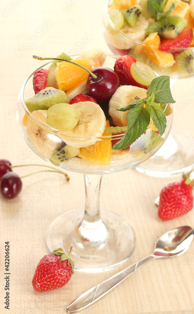 Fresh fruits salad and strawberries on wooden table Fresh fruits salad and strawberries on wooden table