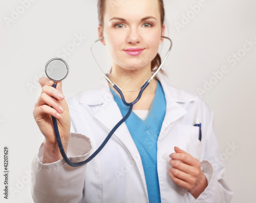 A female doctor with a stethoscope listening, isolated on white