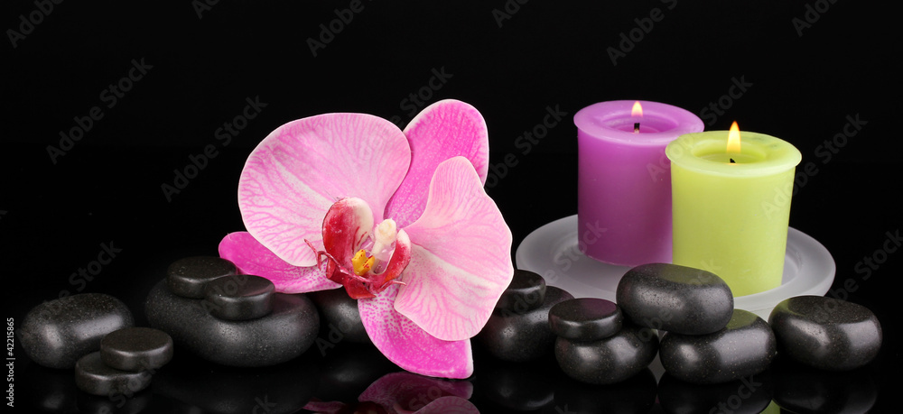 Spa stones with orchid flower and candles isolated on black Spa stones with orchid flower and candles isolated on black